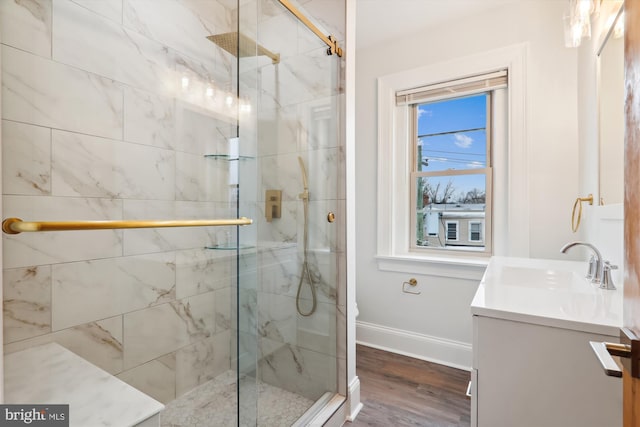 bathroom with a shower with door, vanity, and wood-type flooring