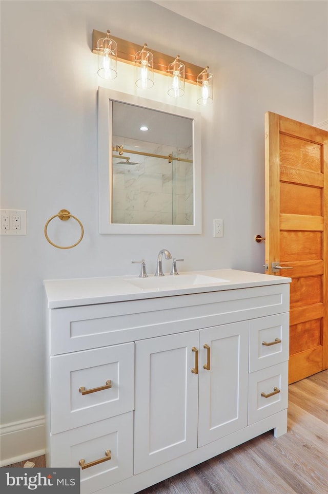 bathroom featuring a shower, hardwood / wood-style floors, and vanity