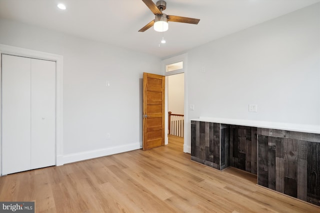 unfurnished bedroom featuring a closet, light hardwood / wood-style flooring, and ceiling fan