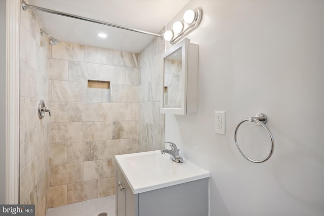 bathroom with vanity and a tile shower