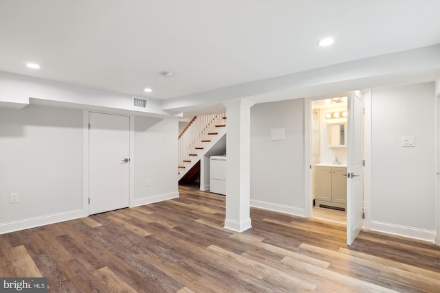 basement featuring light hardwood / wood-style flooring and washer / dryer