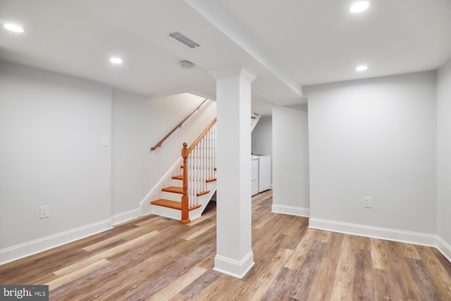 basement with separate washer and dryer and light hardwood / wood-style flooring