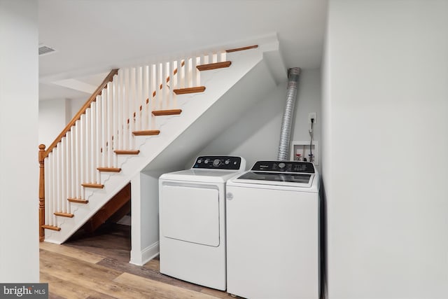 clothes washing area with light wood-type flooring and washing machine and dryer