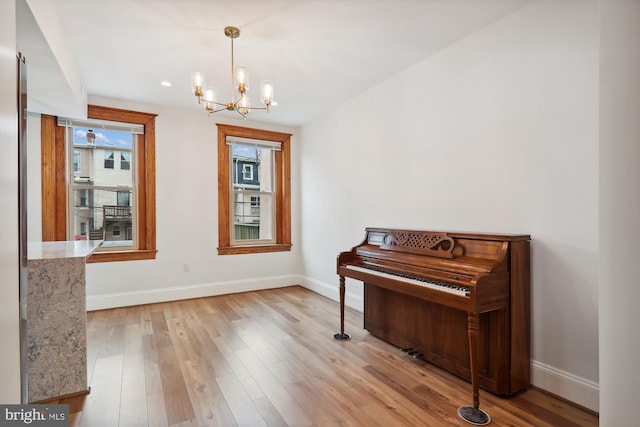 miscellaneous room with a notable chandelier and light hardwood / wood-style floors