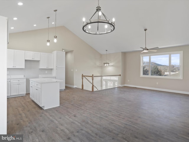 kitchen featuring high vaulted ceiling, white cabinets, hanging light fixtures, and light wood-type flooring