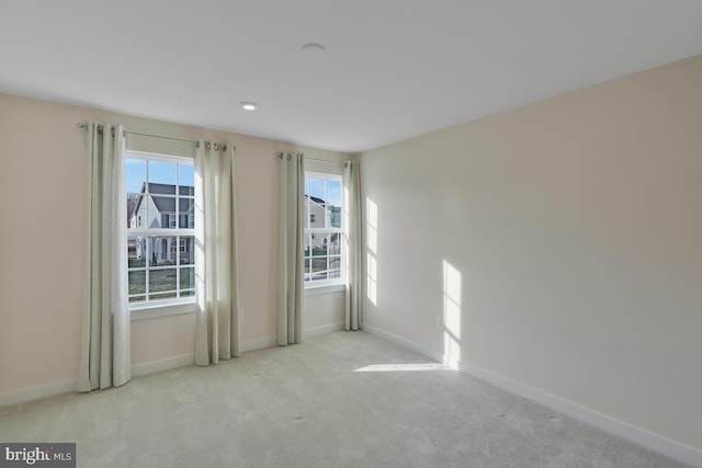 unfurnished room with light carpet and a wealth of natural light