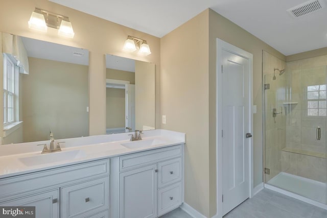 bathroom with tile patterned floors, vanity, and walk in shower