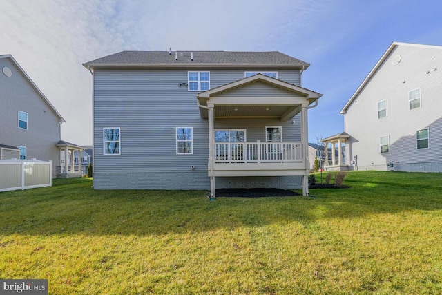 back of property with a yard and a wooden deck