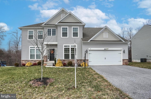 view of front of property with central AC, a front yard, and a garage