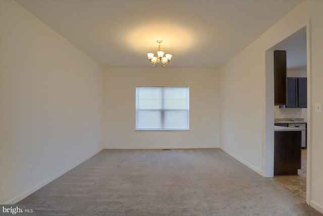 carpeted empty room featuring a notable chandelier