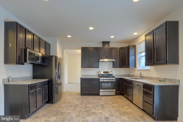 kitchen featuring dark brown cabinets, sink, light stone counters, and stainless steel appliances