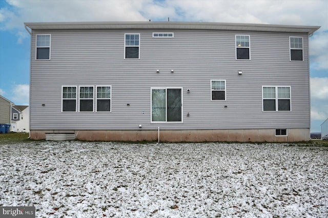 view of snow covered back of property