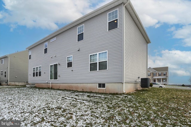 snow covered property with central AC unit