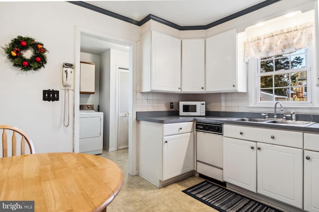 kitchen featuring white appliances, washer / clothes dryer, white cabinetry, and sink