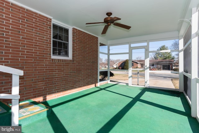 unfurnished sunroom featuring ceiling fan