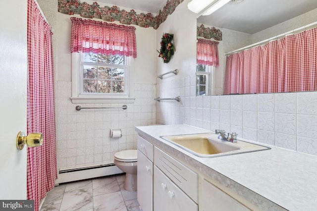 bathroom with vanity, toilet, tile walls, and a baseboard radiator