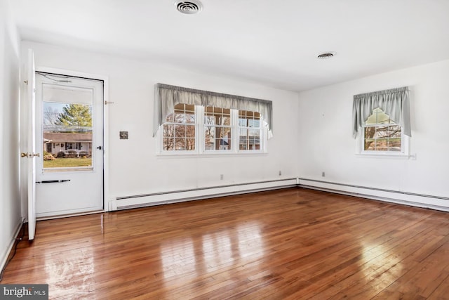 unfurnished dining area with hardwood / wood-style floors and a baseboard radiator