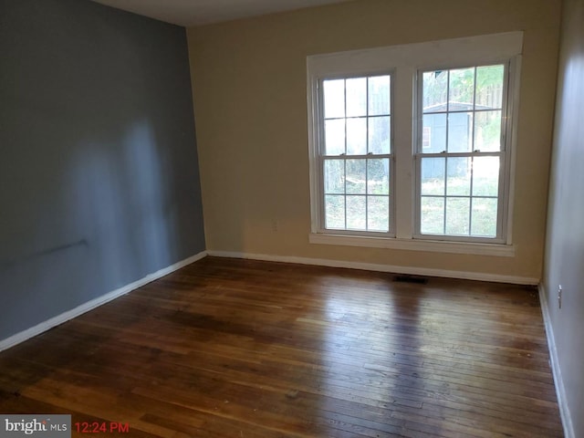 unfurnished room featuring dark wood-type flooring