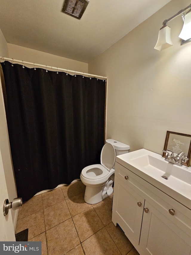 bathroom featuring tile patterned floors, vanity, and toilet