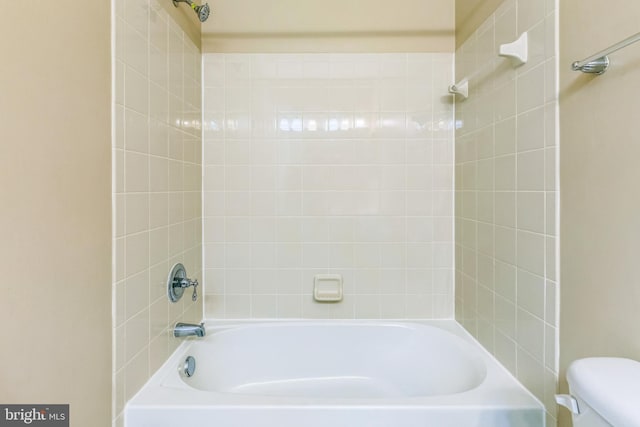 bathroom featuring tiled shower / bath and toilet