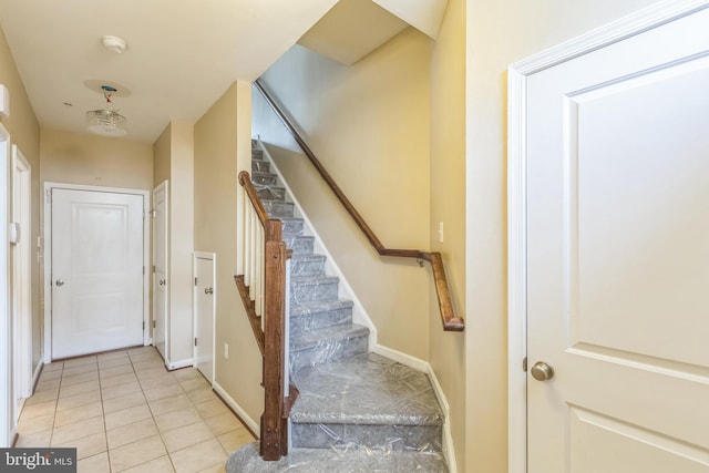 stairs featuring a chandelier and tile patterned floors