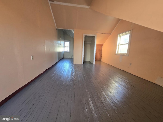 bonus room featuring a healthy amount of sunlight, dark hardwood / wood-style flooring, and vaulted ceiling