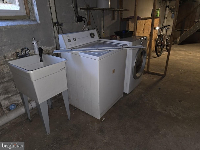 clothes washing area with washing machine and clothes dryer and sink