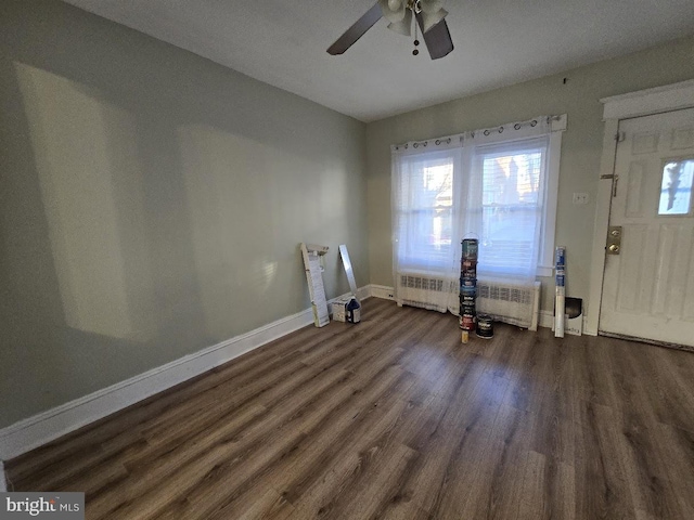 interior space featuring ceiling fan, dark hardwood / wood-style flooring, and radiator