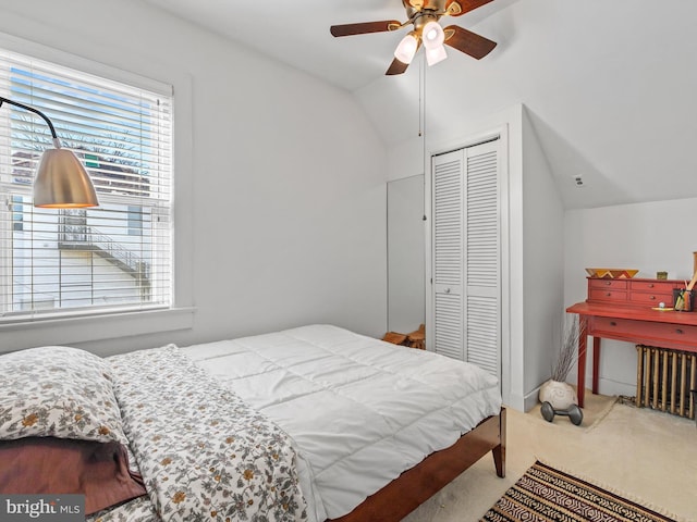 bedroom featuring ceiling fan, light colored carpet, lofted ceiling, and a closet