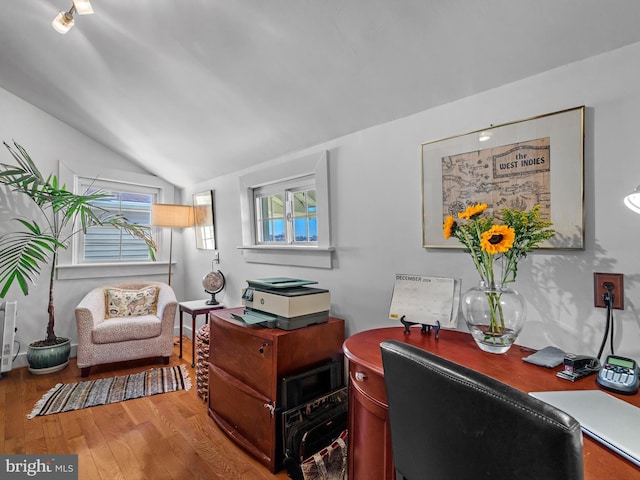 home office featuring light hardwood / wood-style floors and lofted ceiling