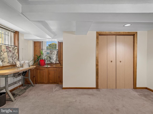 interior space featuring beamed ceiling and light colored carpet