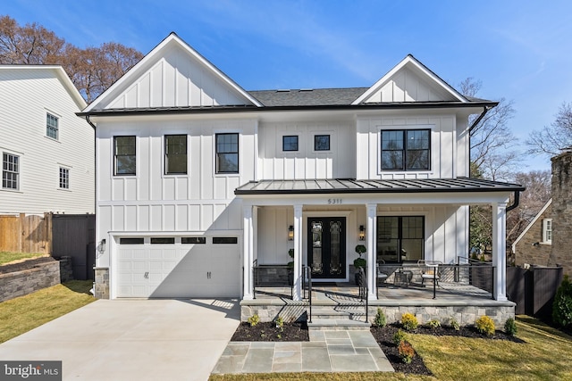 modern inspired farmhouse featuring fence, driveway, a standing seam roof, covered porch, and board and batten siding