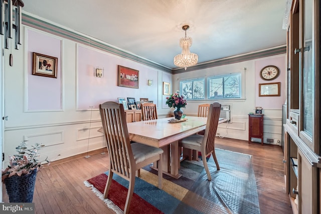 dining space featuring dark hardwood / wood-style flooring, ornamental molding, and a notable chandelier