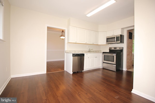 kitchen with pendant lighting, white cabinets, sink, dark hardwood / wood-style flooring, and stainless steel appliances