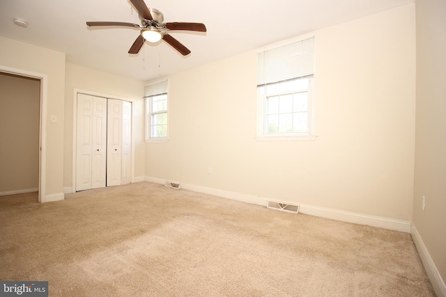 unfurnished bedroom featuring ceiling fan and light colored carpet