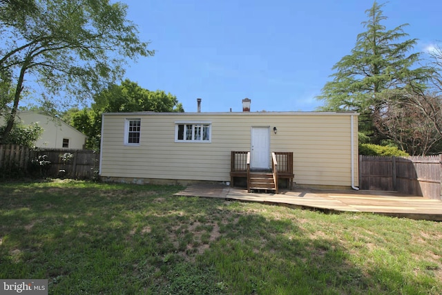 back of house with a deck and a yard