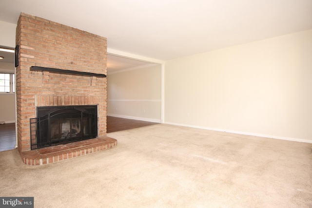 unfurnished living room with crown molding, a fireplace, and carpet