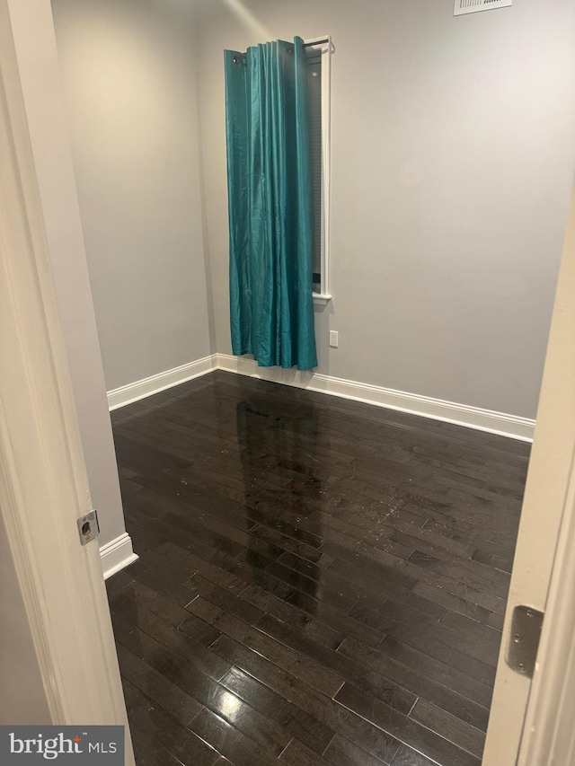 empty room with dark hardwood / wood-style flooring