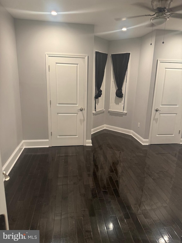 empty room with ceiling fan and dark hardwood / wood-style floors