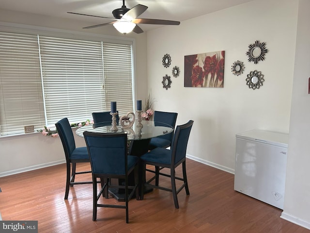 dining space featuring ceiling fan, wood finished floors, a wealth of natural light, and baseboards