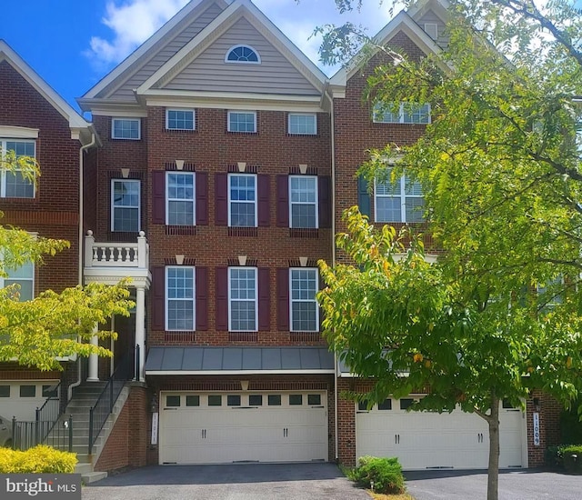 view of front of home featuring a garage, aphalt driveway, and brick siding