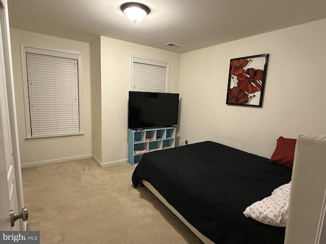 carpeted bedroom with visible vents and baseboards