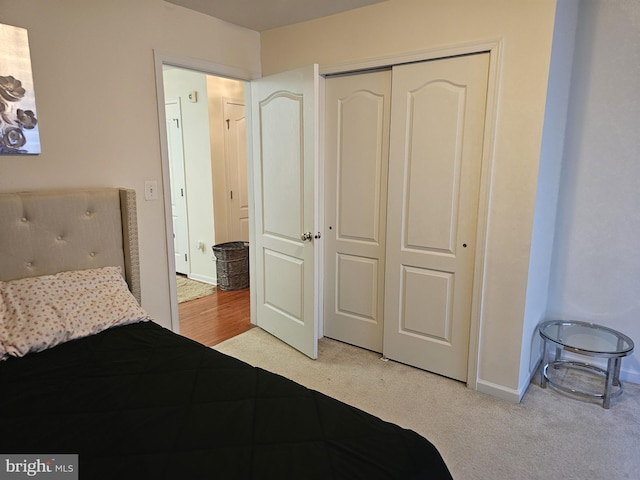 bedroom with light carpet, a closet, and baseboards