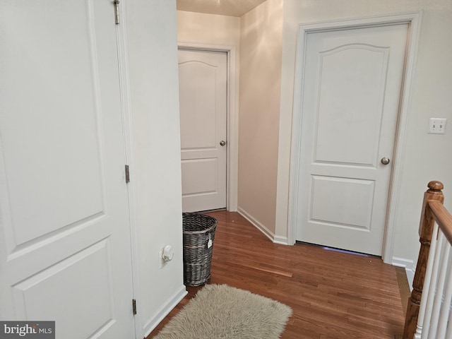 hallway featuring wood finished floors and baseboards