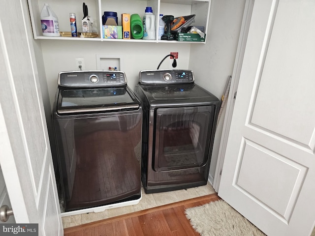 laundry area featuring laundry area, washer and clothes dryer, and wood finished floors