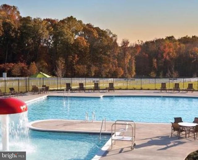 pool with fence and a patio