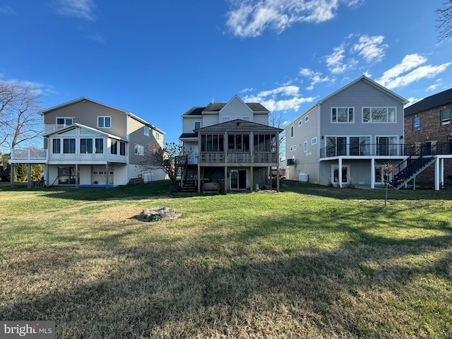 back of property with a yard and a sunroom