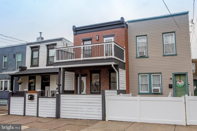 townhome / multi-family property featuring a balcony and cooling unit