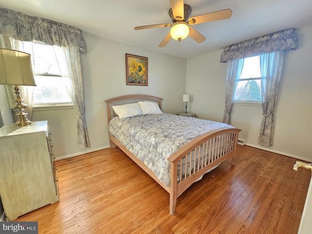 bedroom featuring multiple windows, ceiling fan, and light hardwood / wood-style flooring