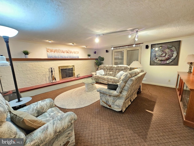 carpeted living room with crown molding, a fireplace, track lighting, and a textured ceiling